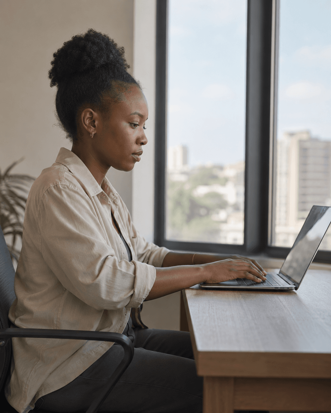 Working at a laptop by a window over the city