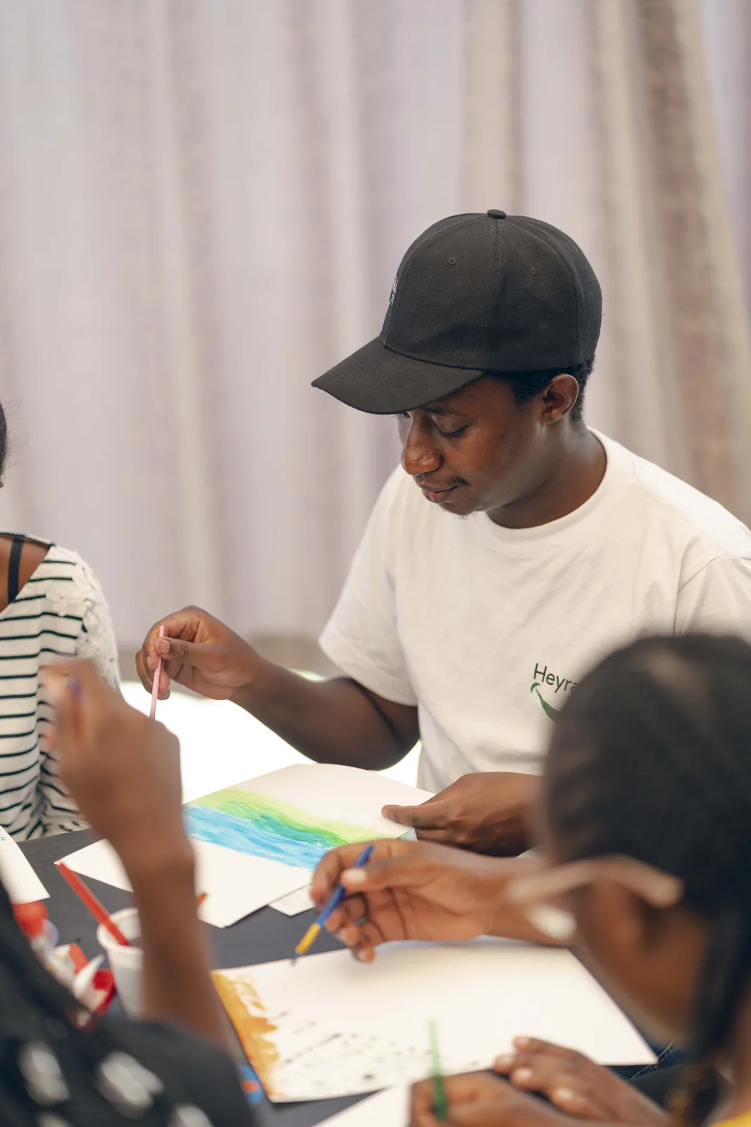 Moenga, Heyrafiki's founder, painting alongside young people during a community art session in Nairobi